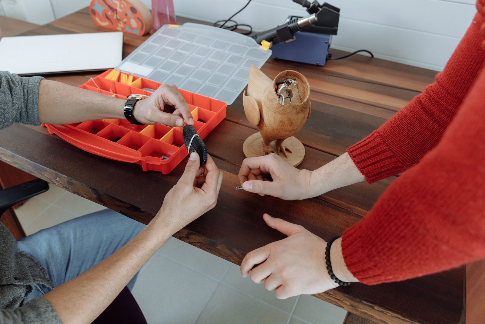 Zwei Personen arbeiten gemeinsam an einem Modellbauteil